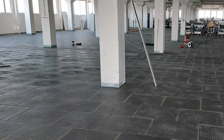 Mimořádně odolná plastová podlaha do haly s pásovou výrobou